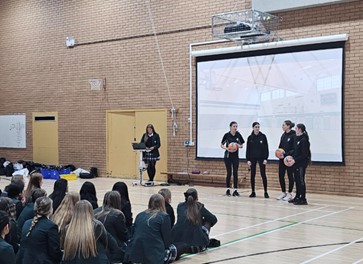 Year 10 students presenting an assembly in school Sports Hall.