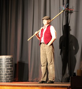 student holding chimney cleaning broom